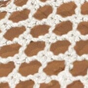 Close-up of cream paper netting fabric with open crisscross mesh pattern.