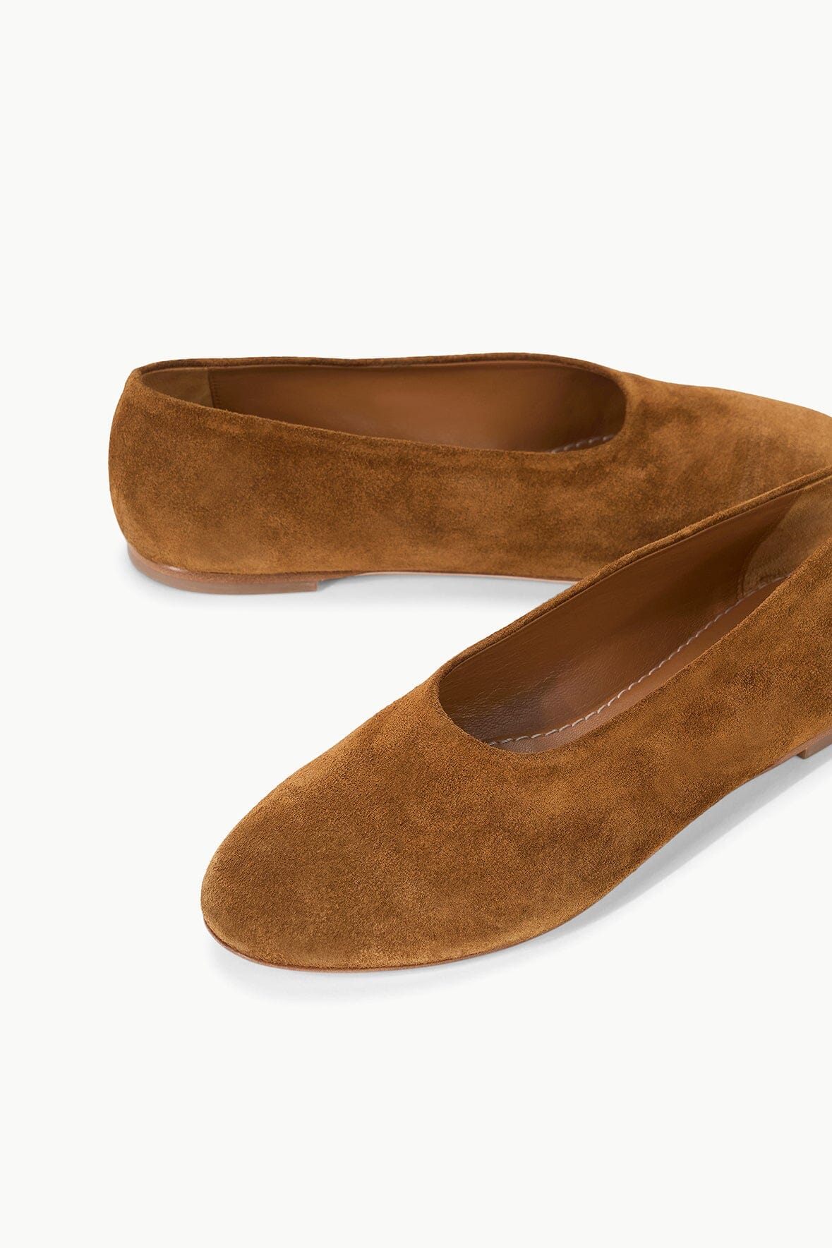 Tan suede ballet flats with round toe and slip-on design