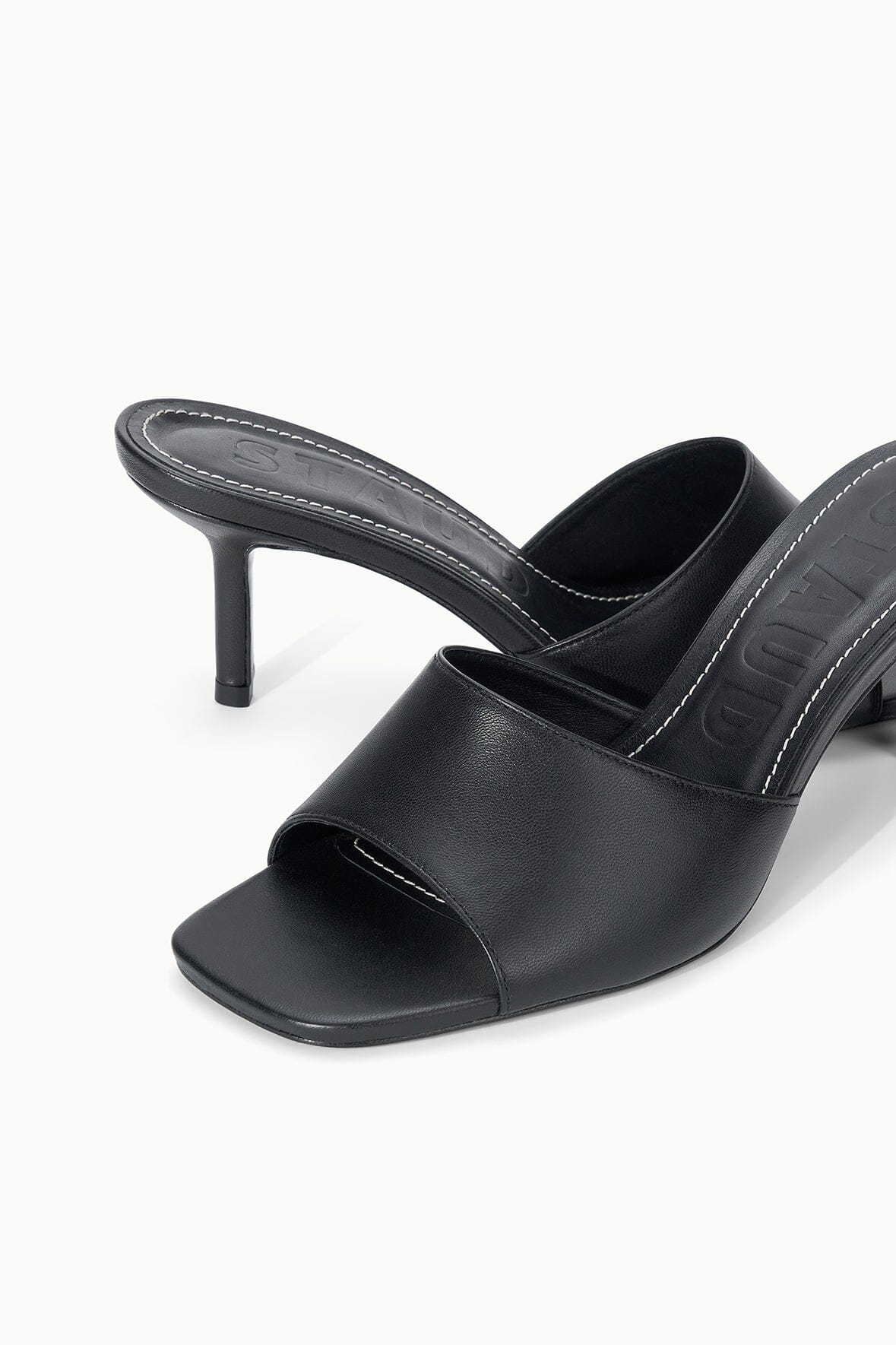 Black leather mule with open toe, stitched strap detail, and stiletto heel