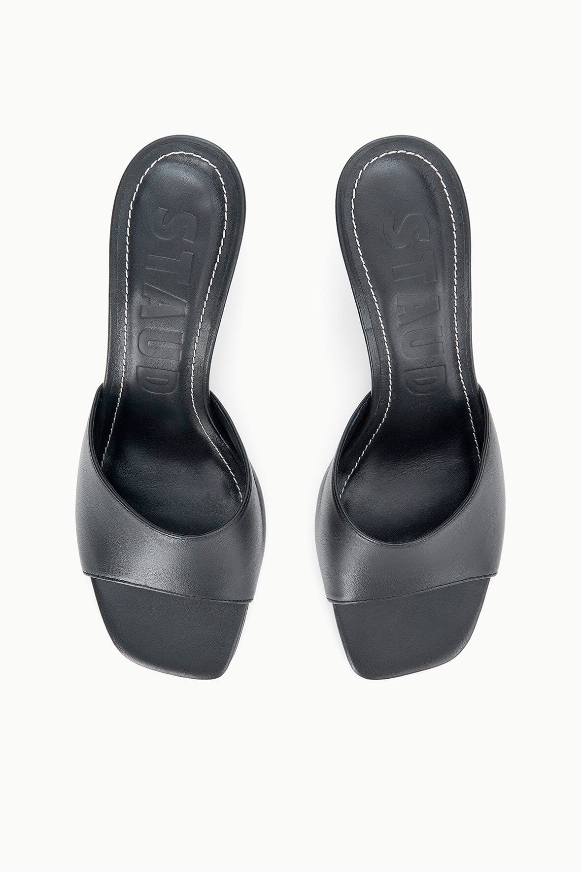 Pair of black leather mules shown from back with stiletto heel
