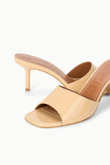 Tan patent leather open-toe mule with slim stiletto heel, close angled view