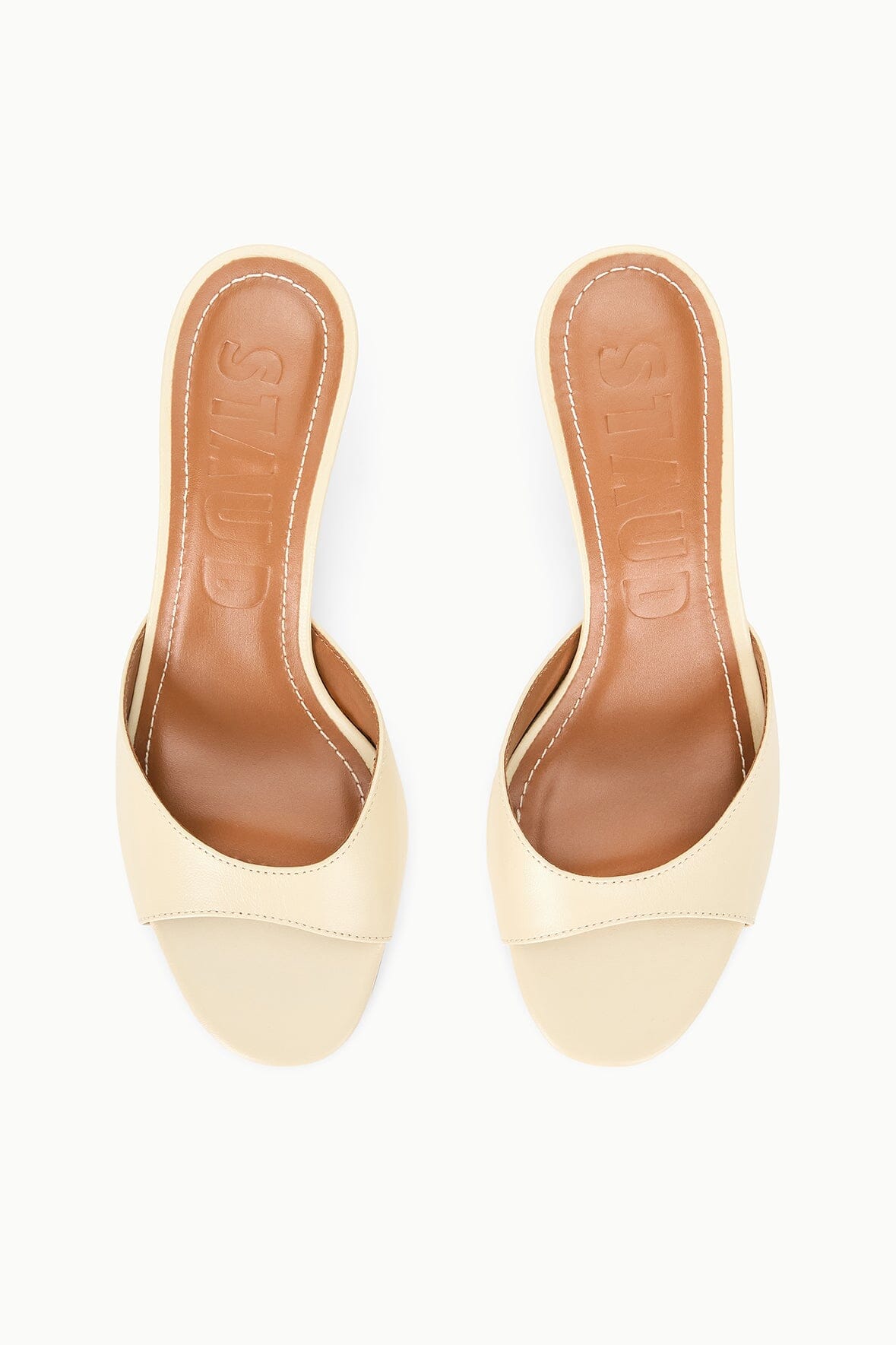 Cream wedge slide sandals showing open toe cutout and tan insoles