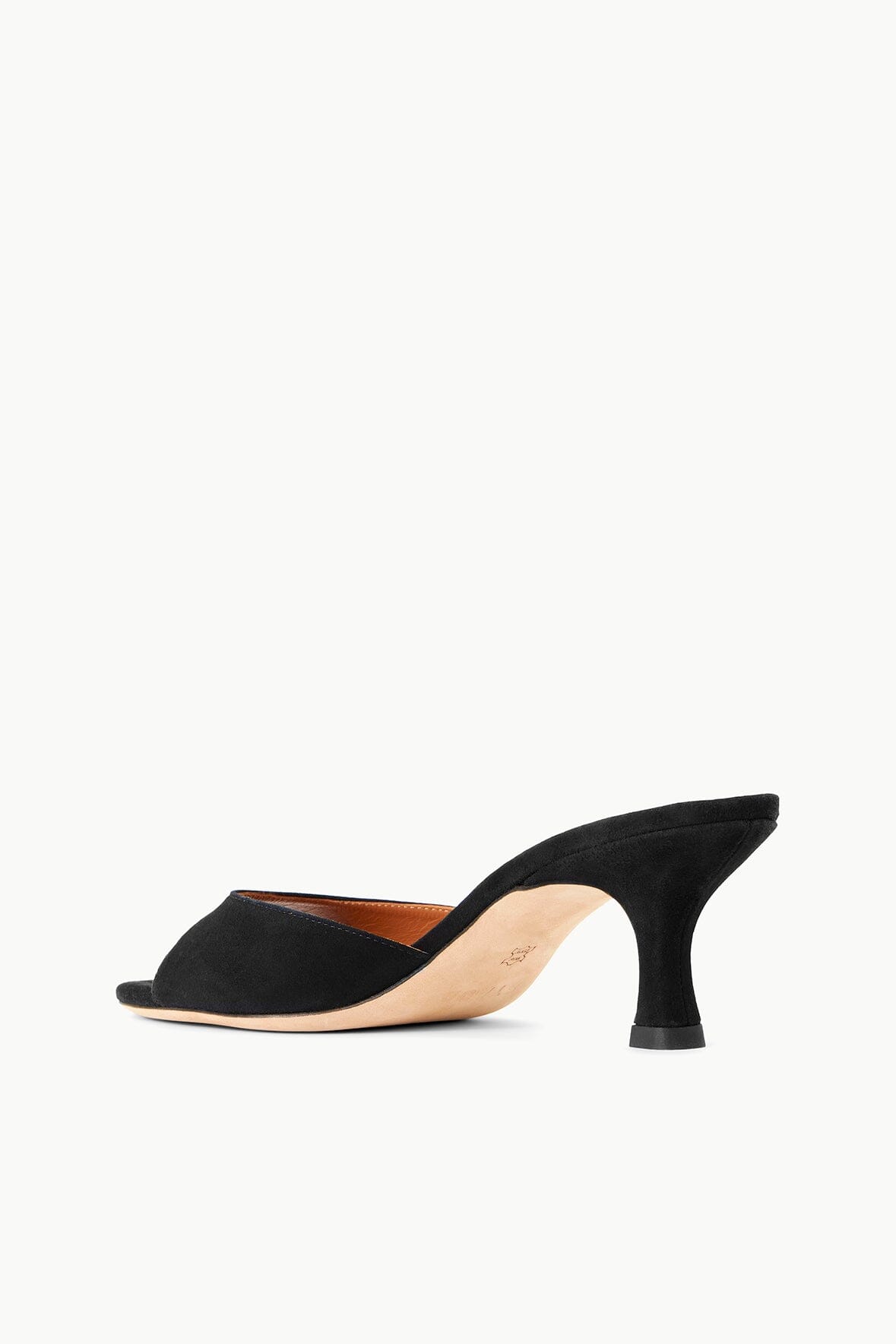 Black suede mule with open toe and mid heel, angled view