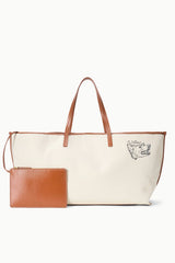Cream canvas tote bag with tan handles, dog logo, and matching leather pouch