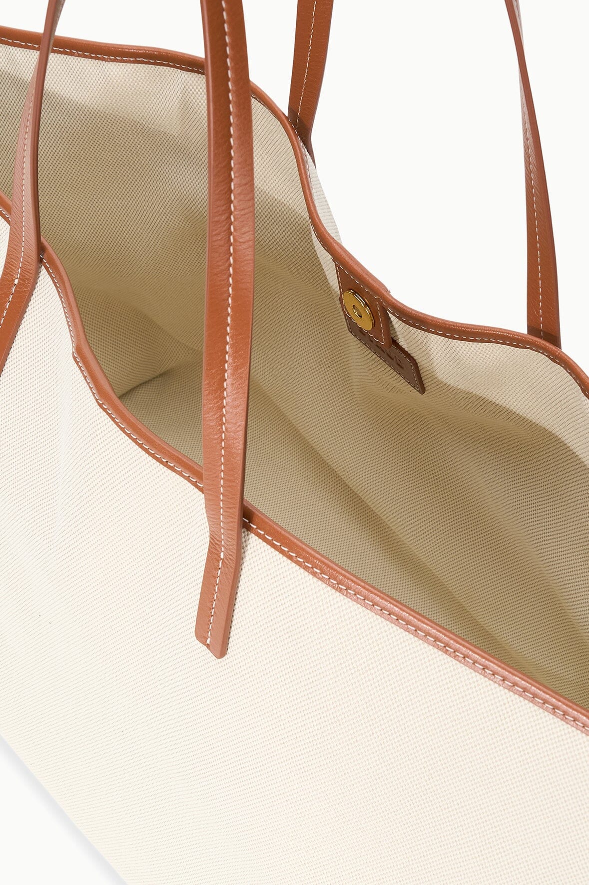 Cream canvas tote interior with tan leather trim and open top