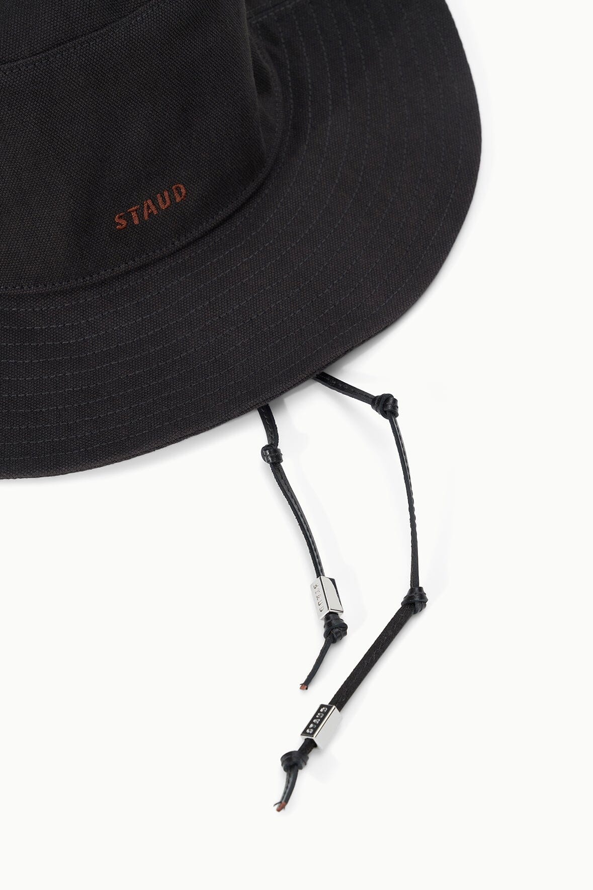 Dark brown bucket hat close-up of chin strap cord and small logo stitch