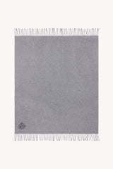 Grey cashmere blanket square with fringe border and small embroidered emblem