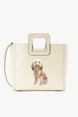 Cream leather tote bag with top handle, pet portrait patch, and square strap frame.