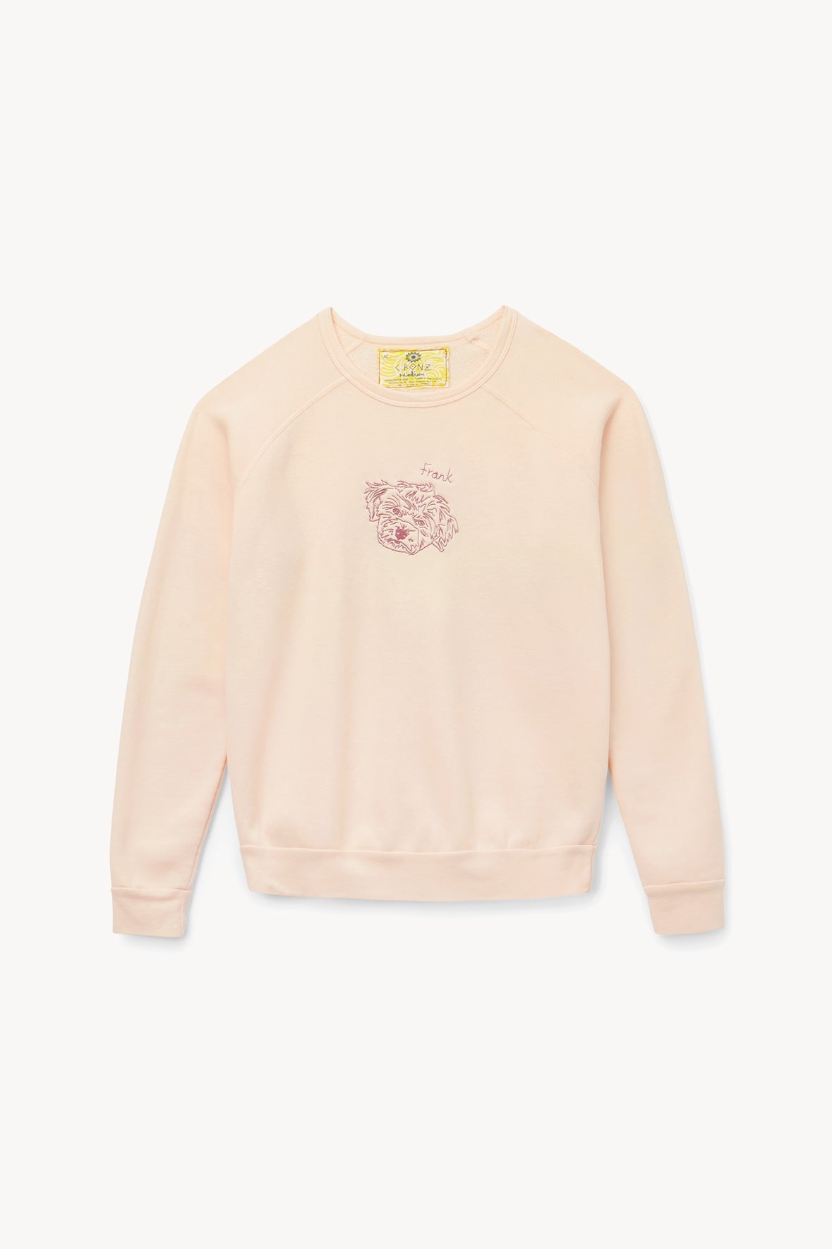 Light pink crewneck sweatshirt with small chest graphic and long sleeves