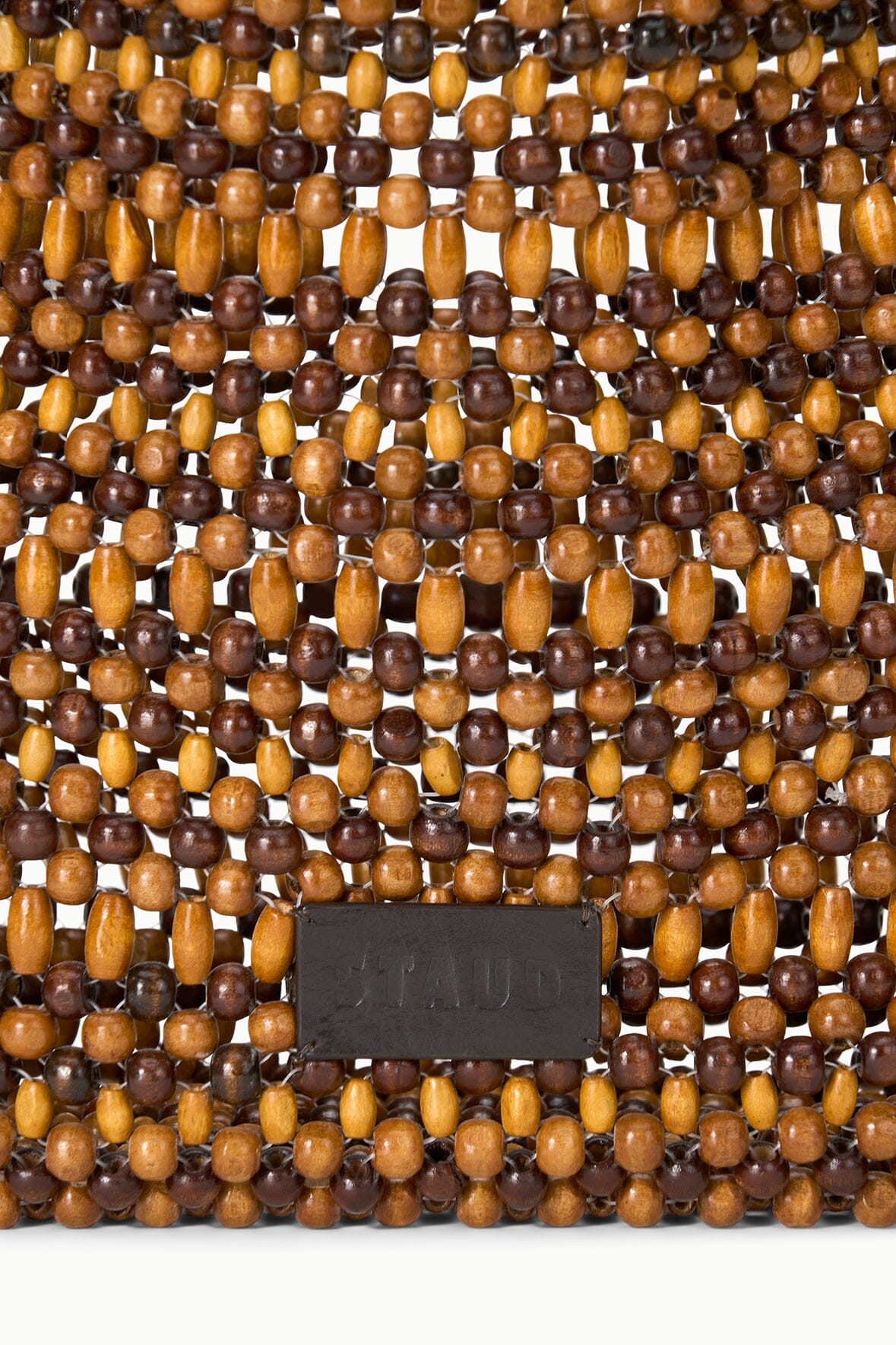 Close-up of multi wood beads on Drift shoulder bag with black leather brand patch