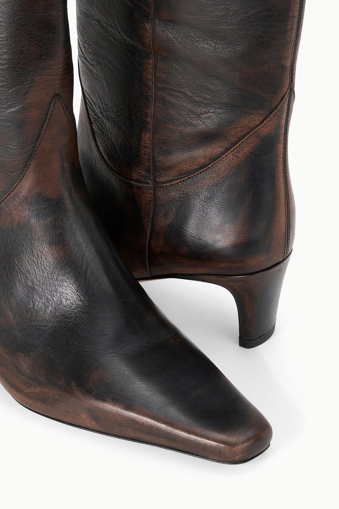 Close-up of dark brown distressed western boot shaft with stitched panels