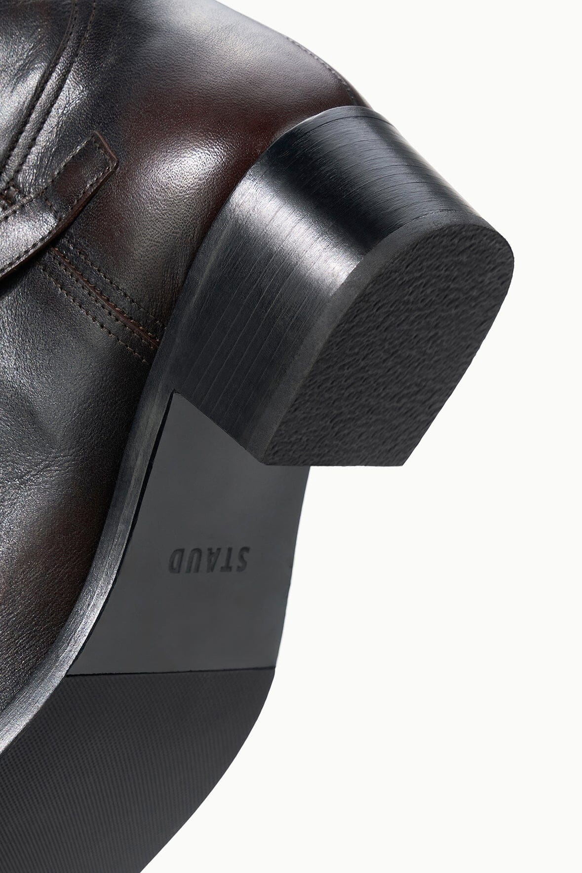 Low block heel of espresso boot with visible brand marking on outsole