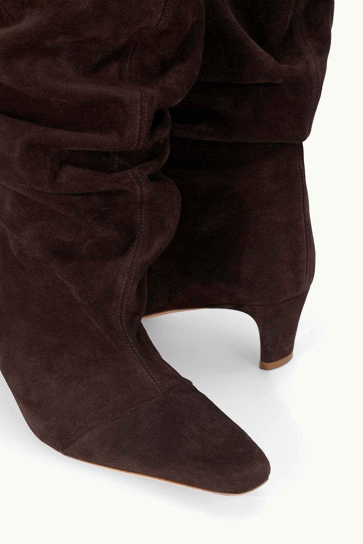 Brown suede slouch boot with pointed toe and stitched ruched shaft, close-up