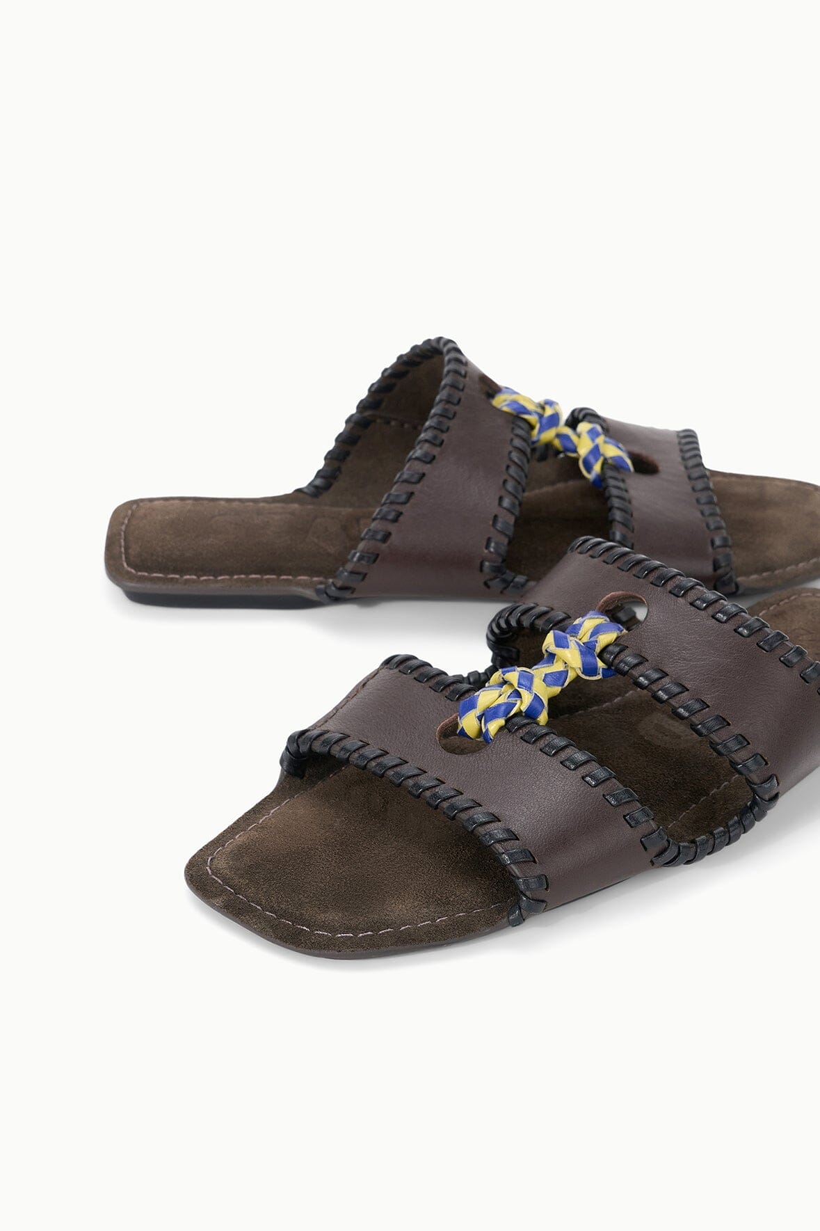 Espresso-brown slide sandals with braided straps and blue-yellow bow accents