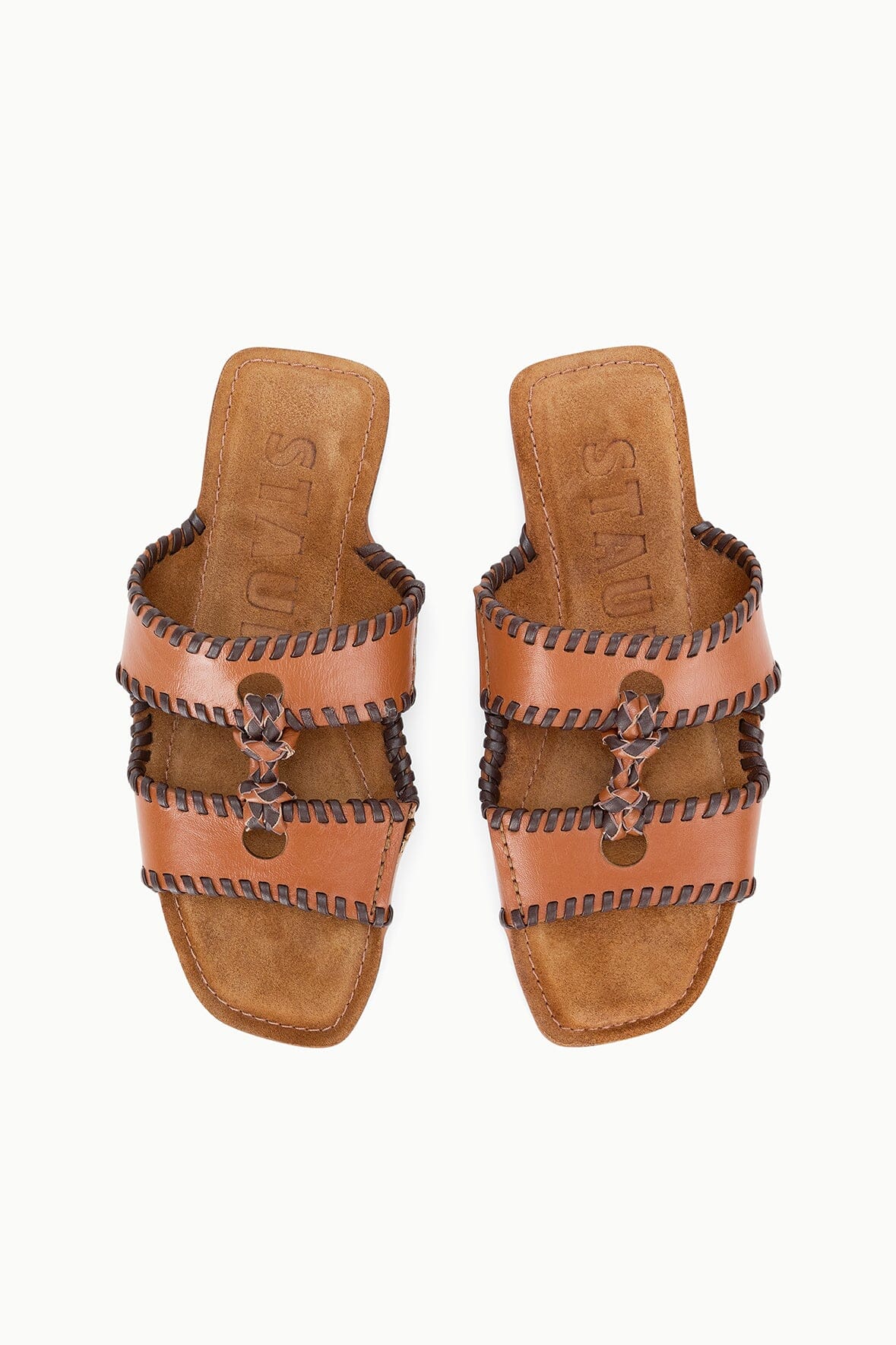 Tan leather slide sandals with cross straps, stitched detailing, and bow accents