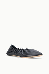 Black flat sneaker shoe, low profile with gathered upper, side view