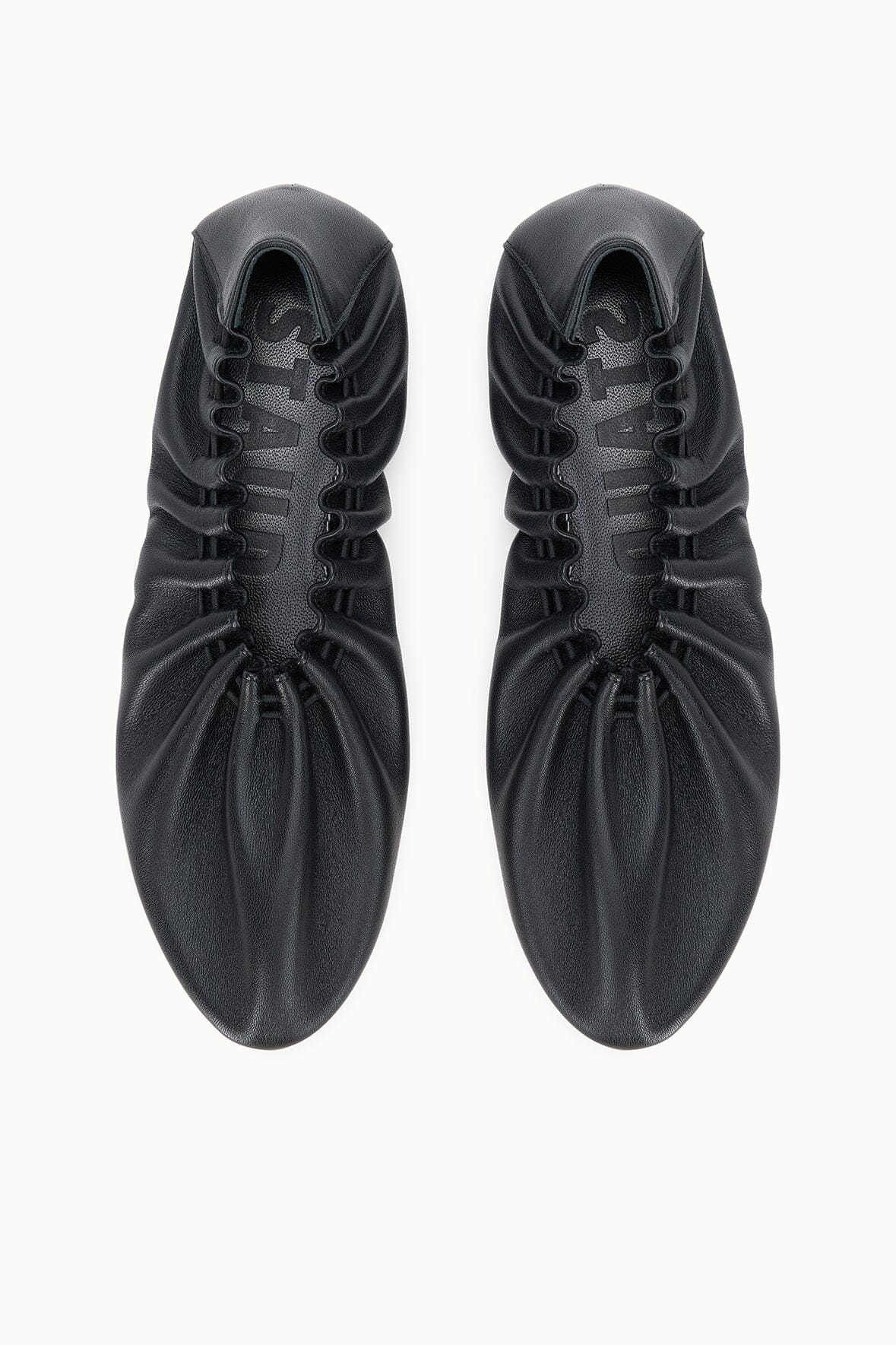 Black flat sneakers, top view of lace-up uppers and rounded toe