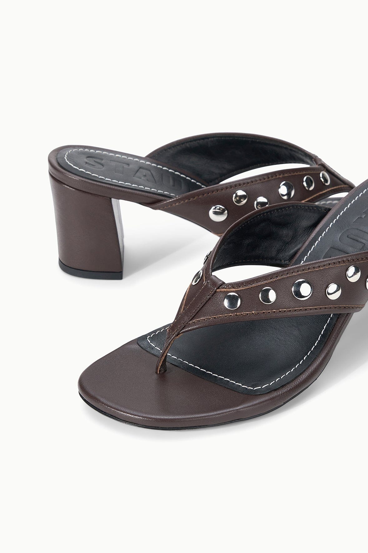 Dark brown studded thong heel sandals with silver eyelet accents, angled view