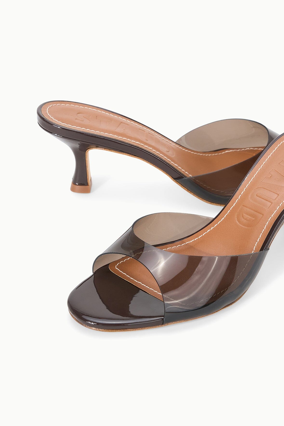 Espresso clear-strap mule with tan insole and mid block heel, angled close-up