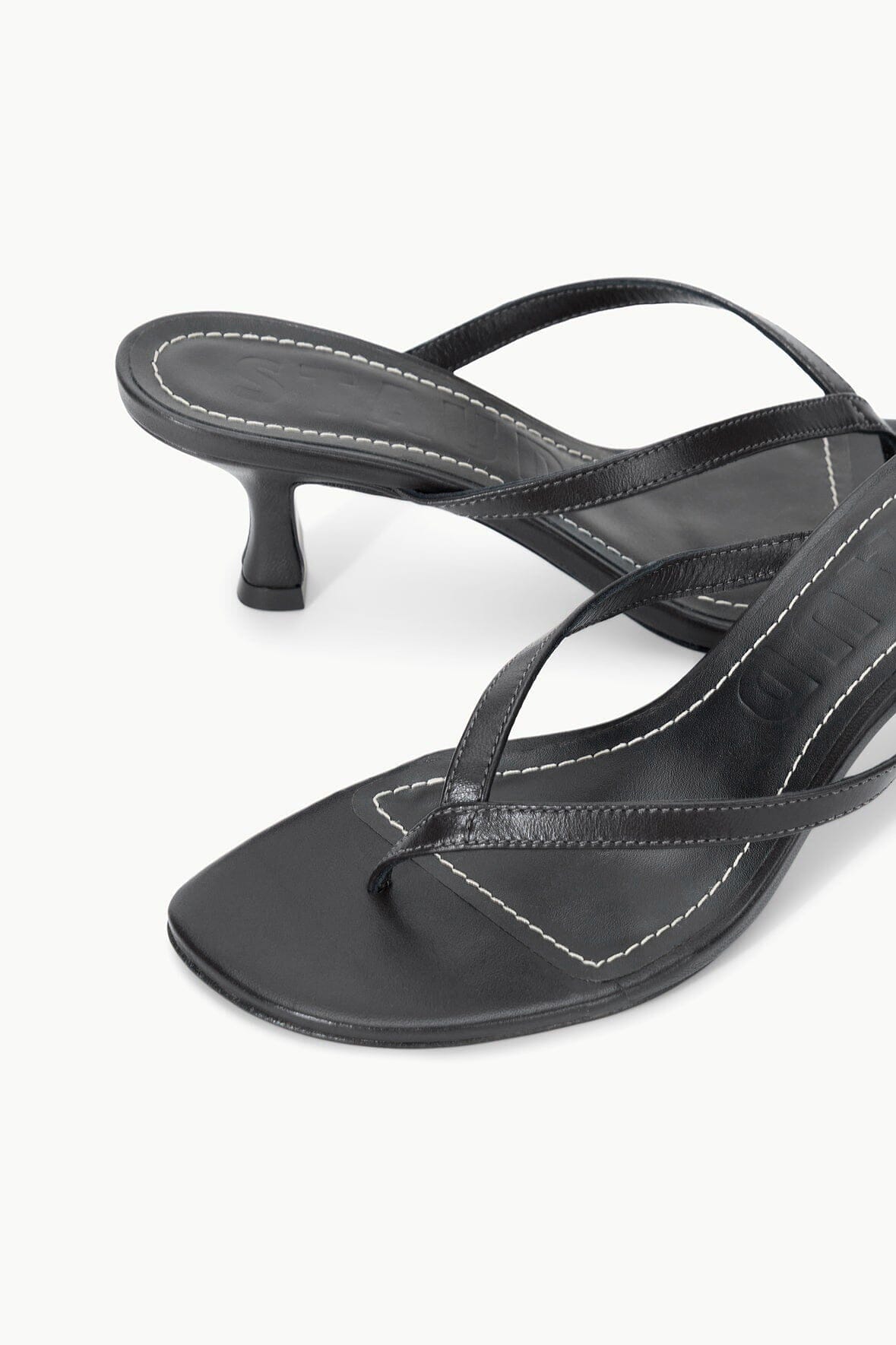 Black kitten-heel thong sandals with thin cross straps and stitched detailing