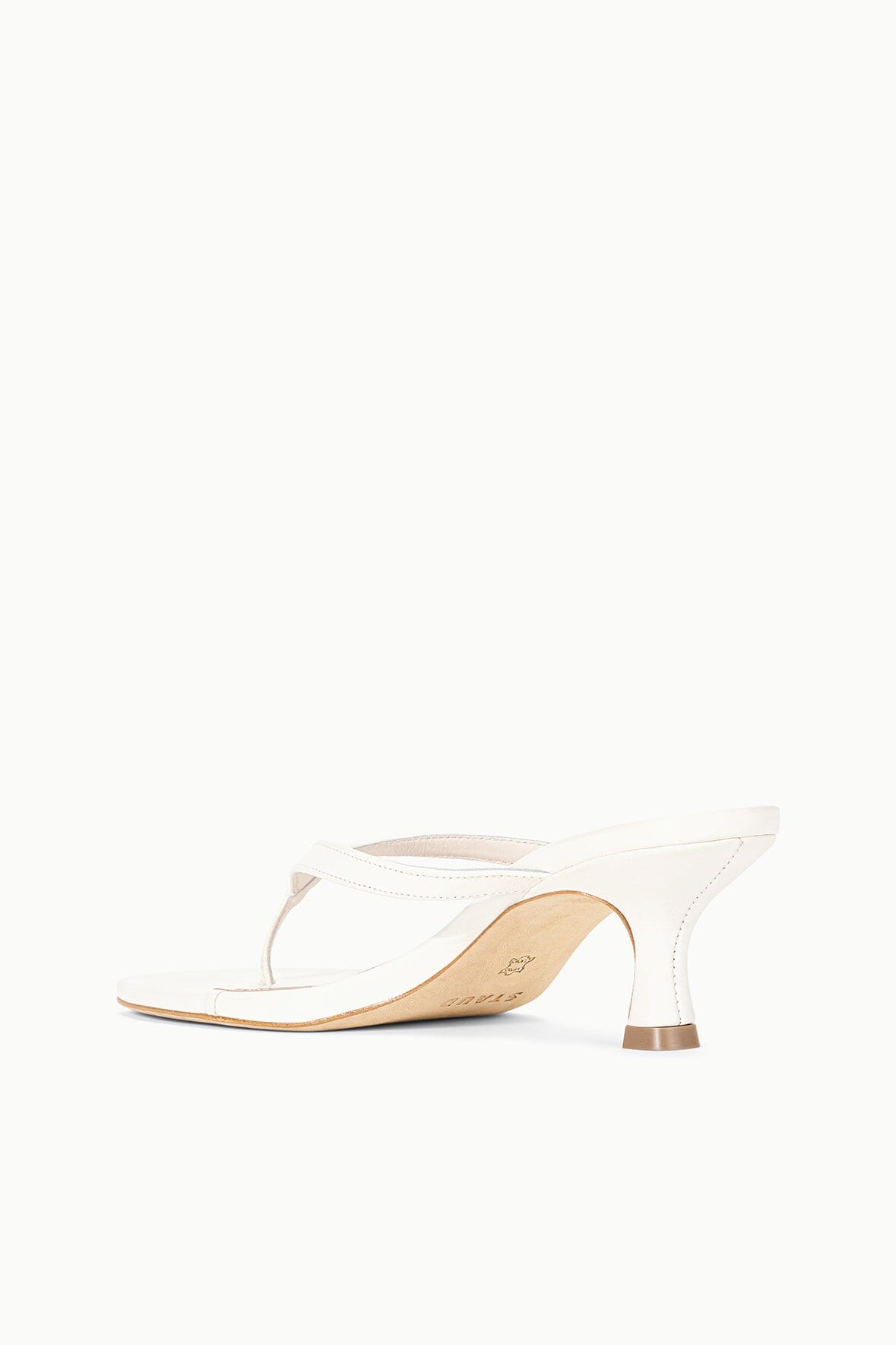 White slingback kitten-heel sandal with open toe, low heel, and tan outsole trim