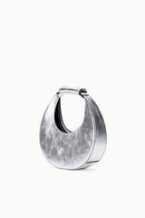 Silver crescent bag with side handle and open top, inner lining visible