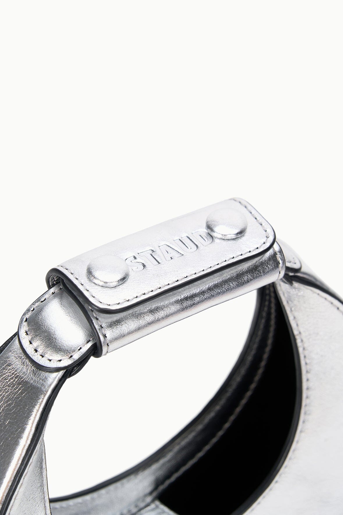 Silver top handle bar with snap button closure detail, black interior