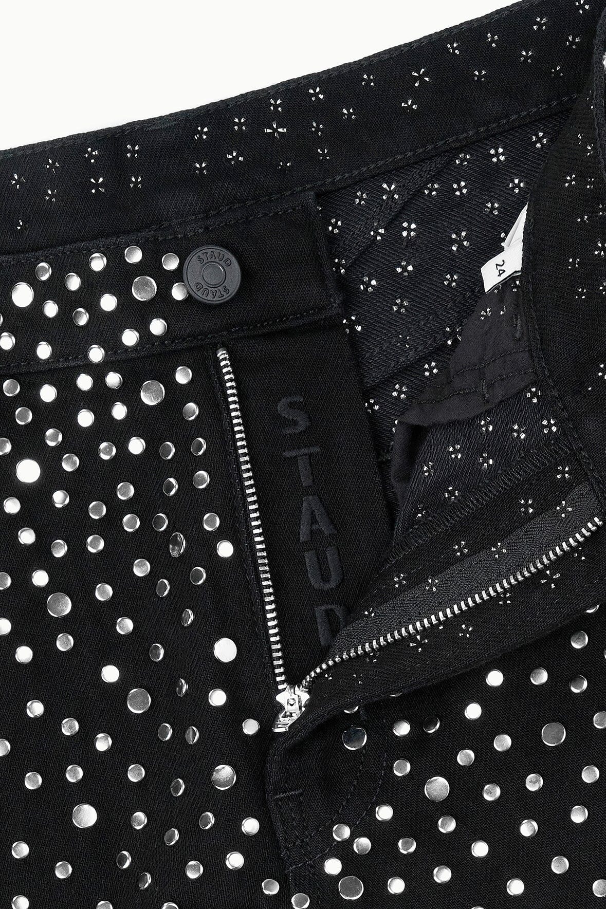 Black jeans featuring silver studs, front button closure, and zipper fly.