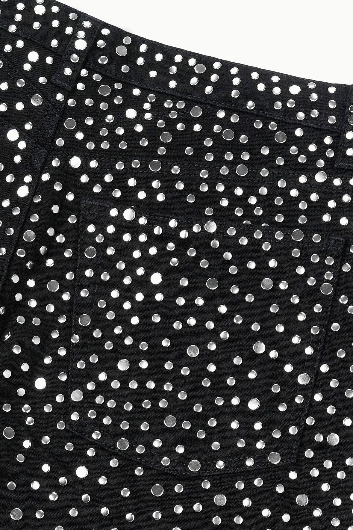 Black jeans with dense silver stud rows and a wide waistband area.