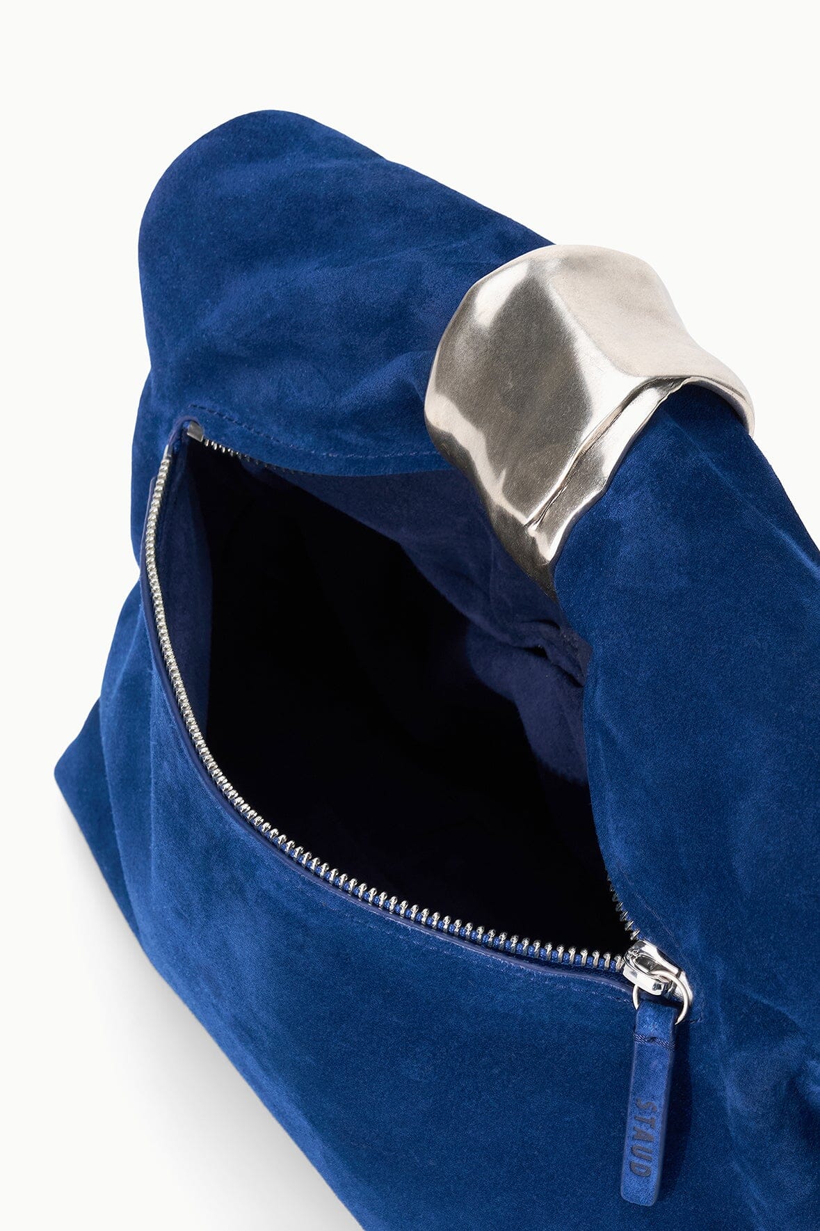 Cobalt suede cuff clutch with open zipper and dark interior lining