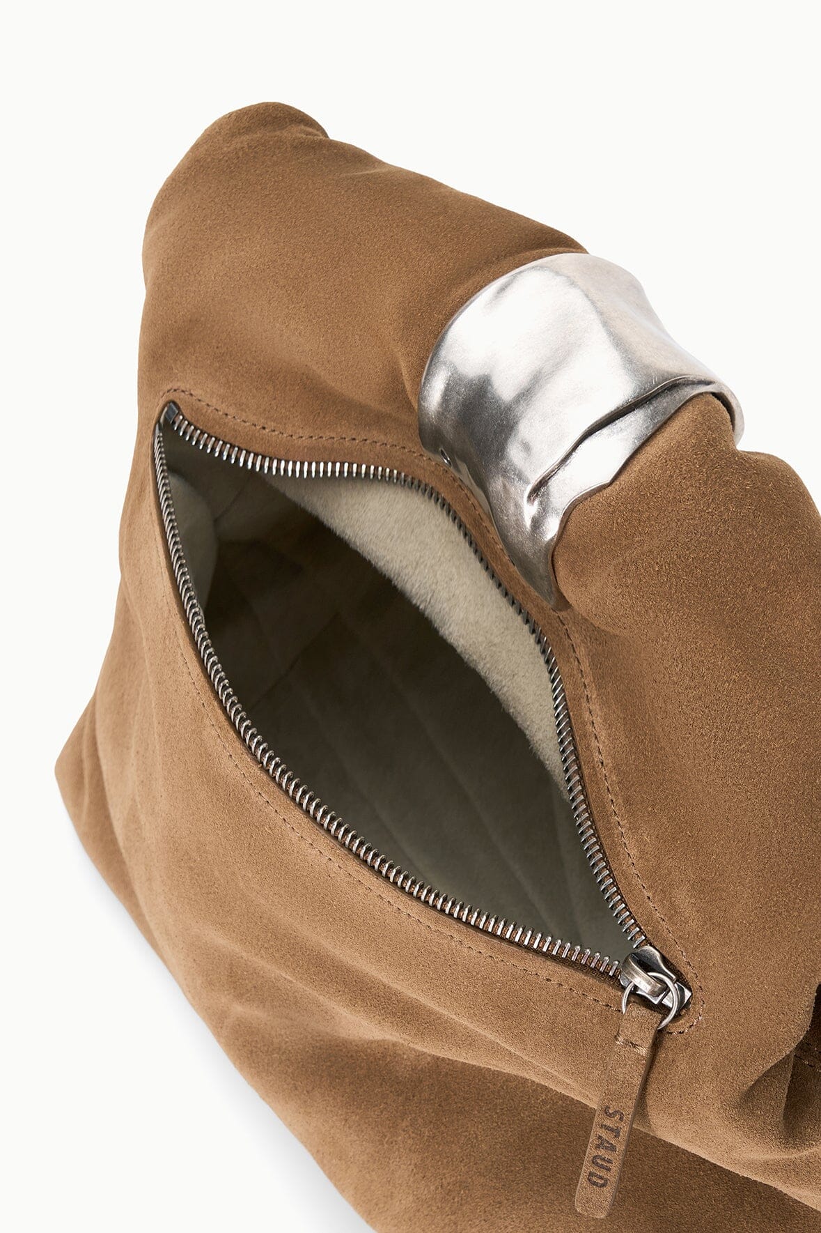 Husk brown cuff clutch shown side-on with front zipper and dark interior