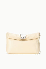 Cream cuff clutch with silver clasp and shoulder strap, front flap detail.