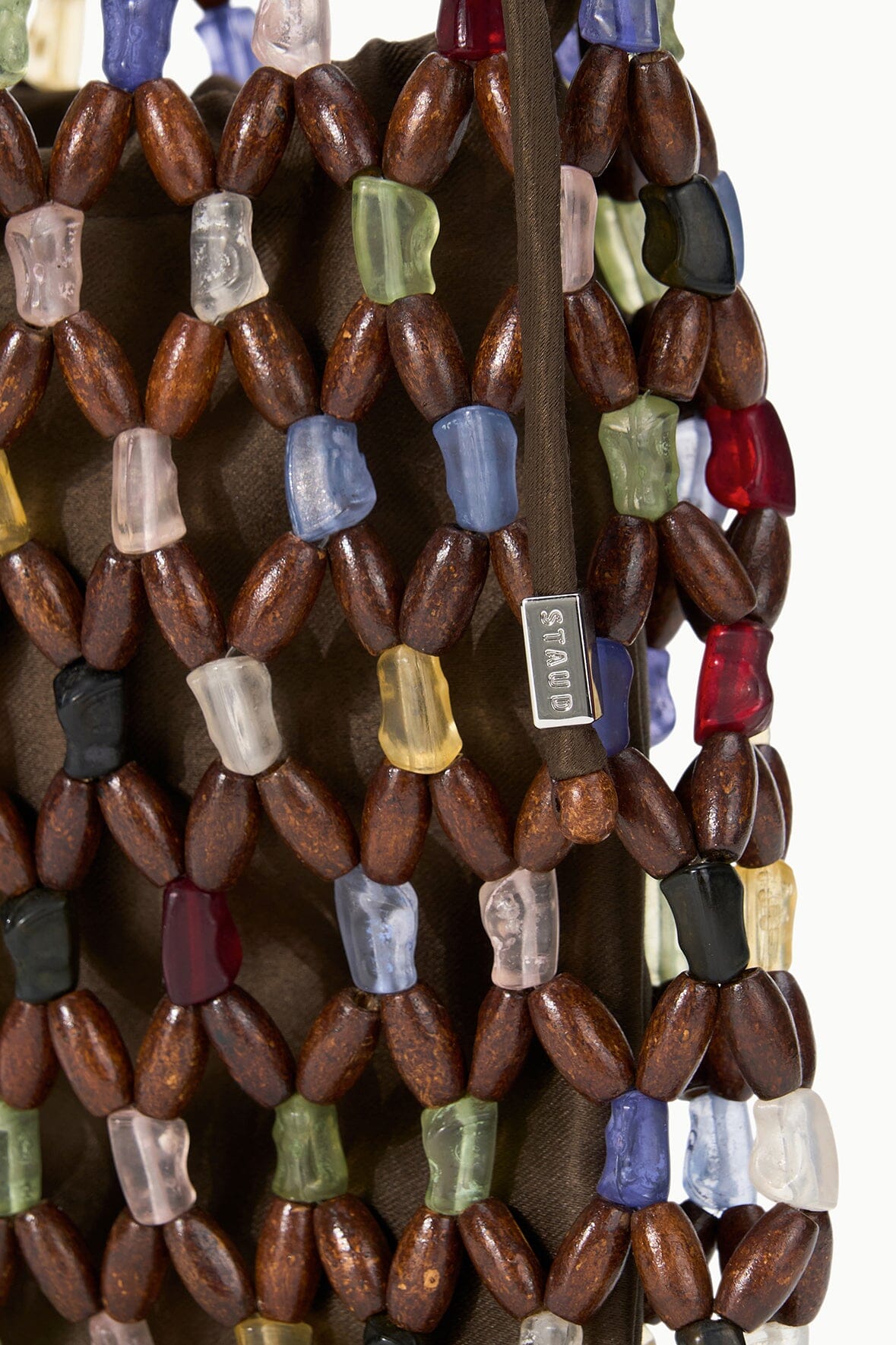 Tote bag beadwork with brown, clear, blue, green, and red oval beads in rows