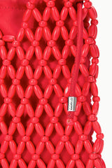 Red beaded drawstring bucket bag with dangling tassels and small logo tag
