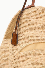Large natural raffia bag with brown leather straps and woven palm pattern