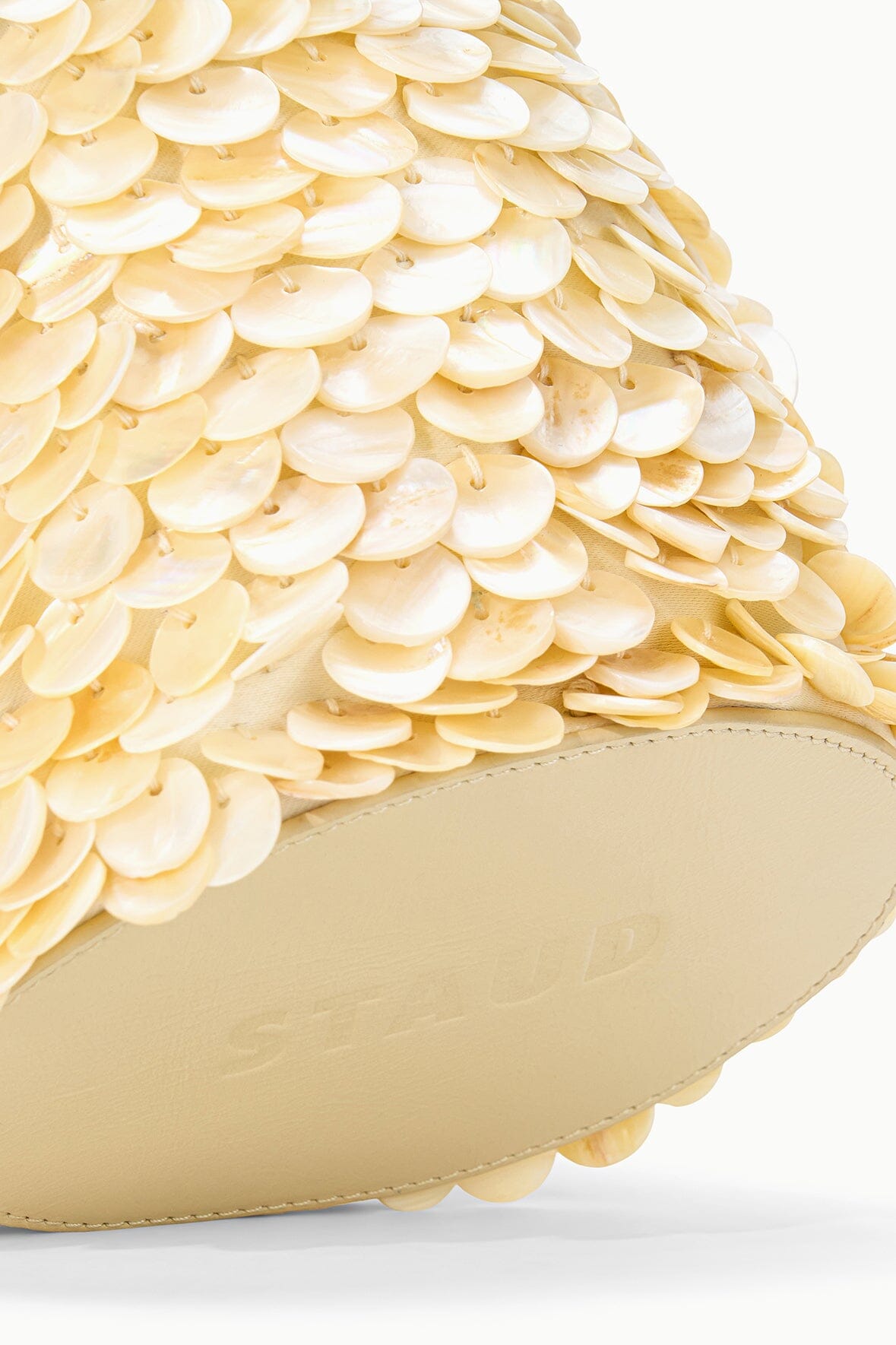 Close-up of cream sequin texture on LILA mini bag with beige base edging