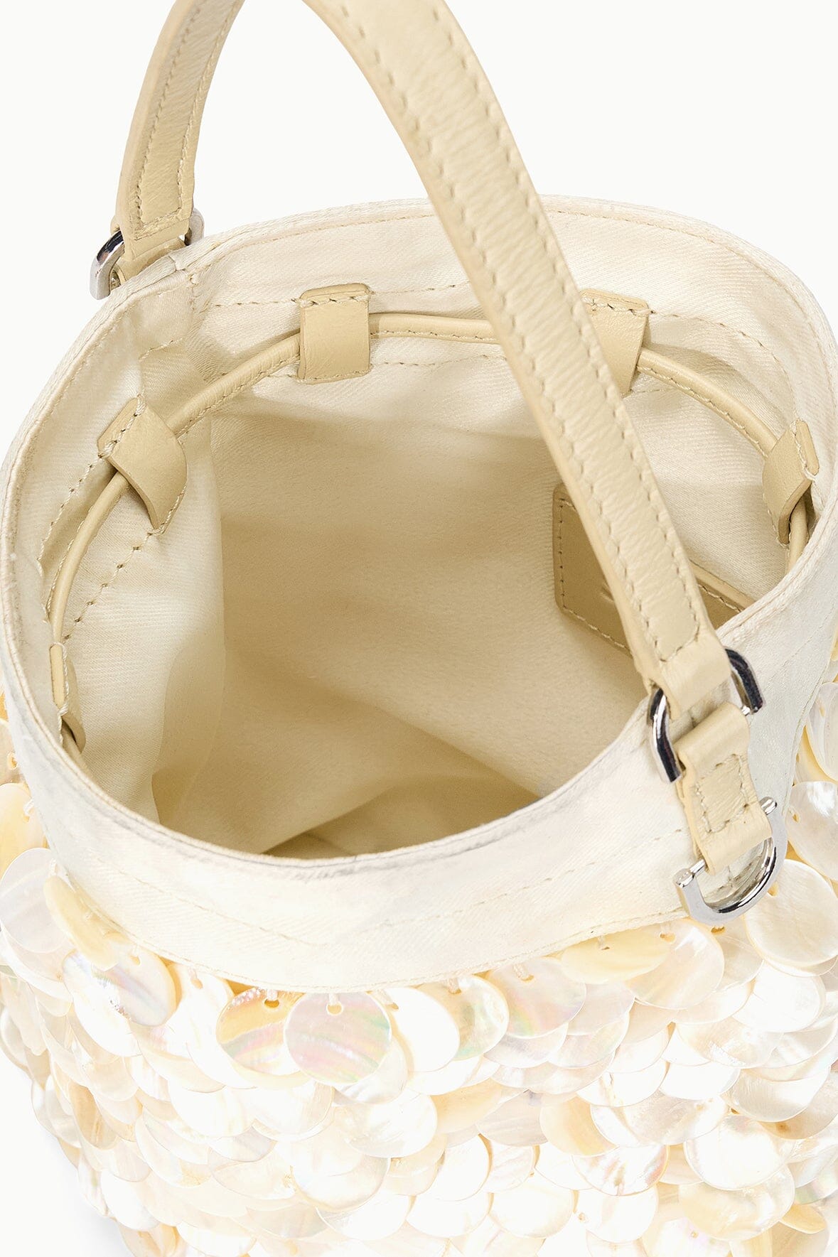 Open LILA mini bag interior with cream lining and top flap straps, close-up