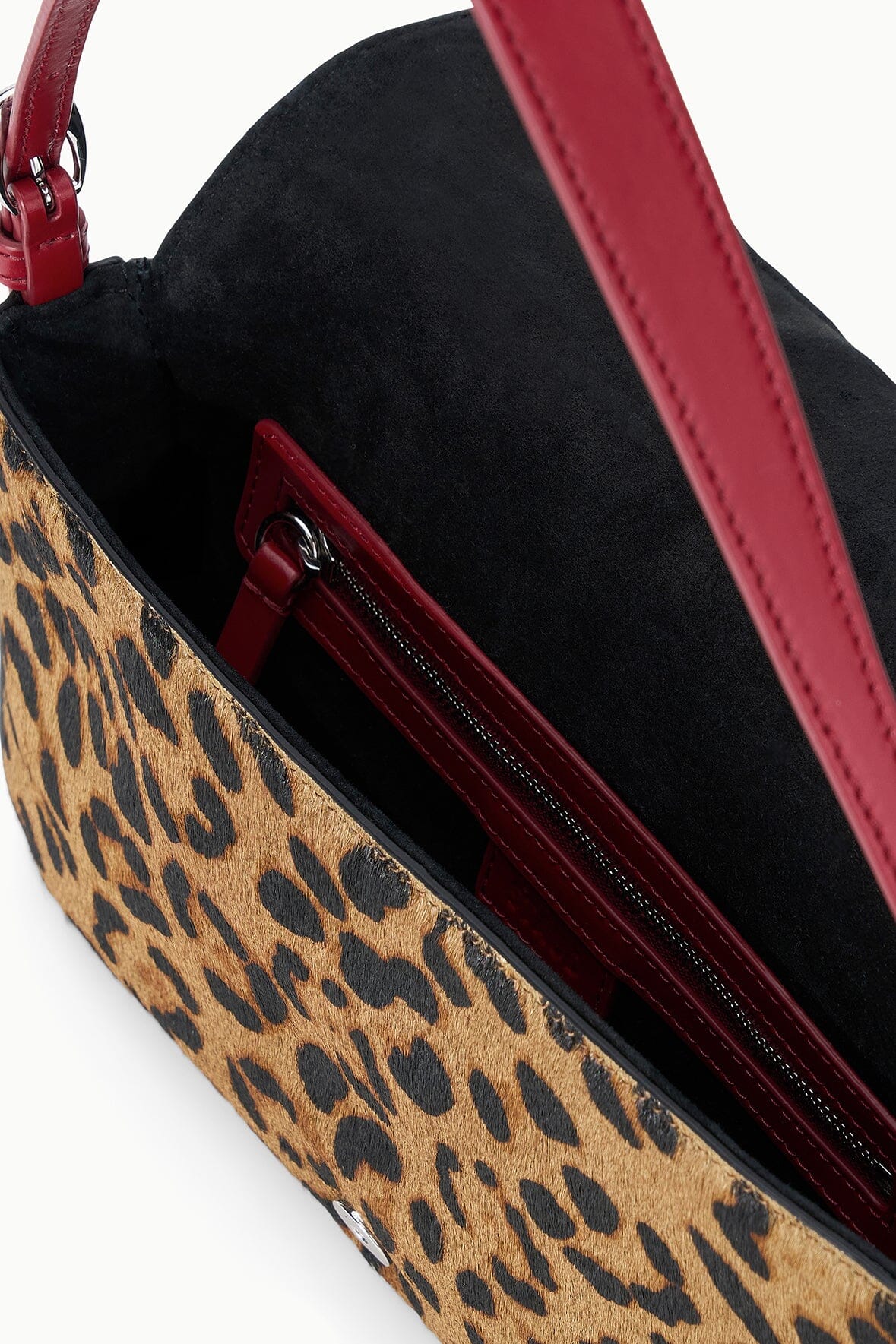 Cheetah-print shoulder bag interior with black lining and red zipper pocket