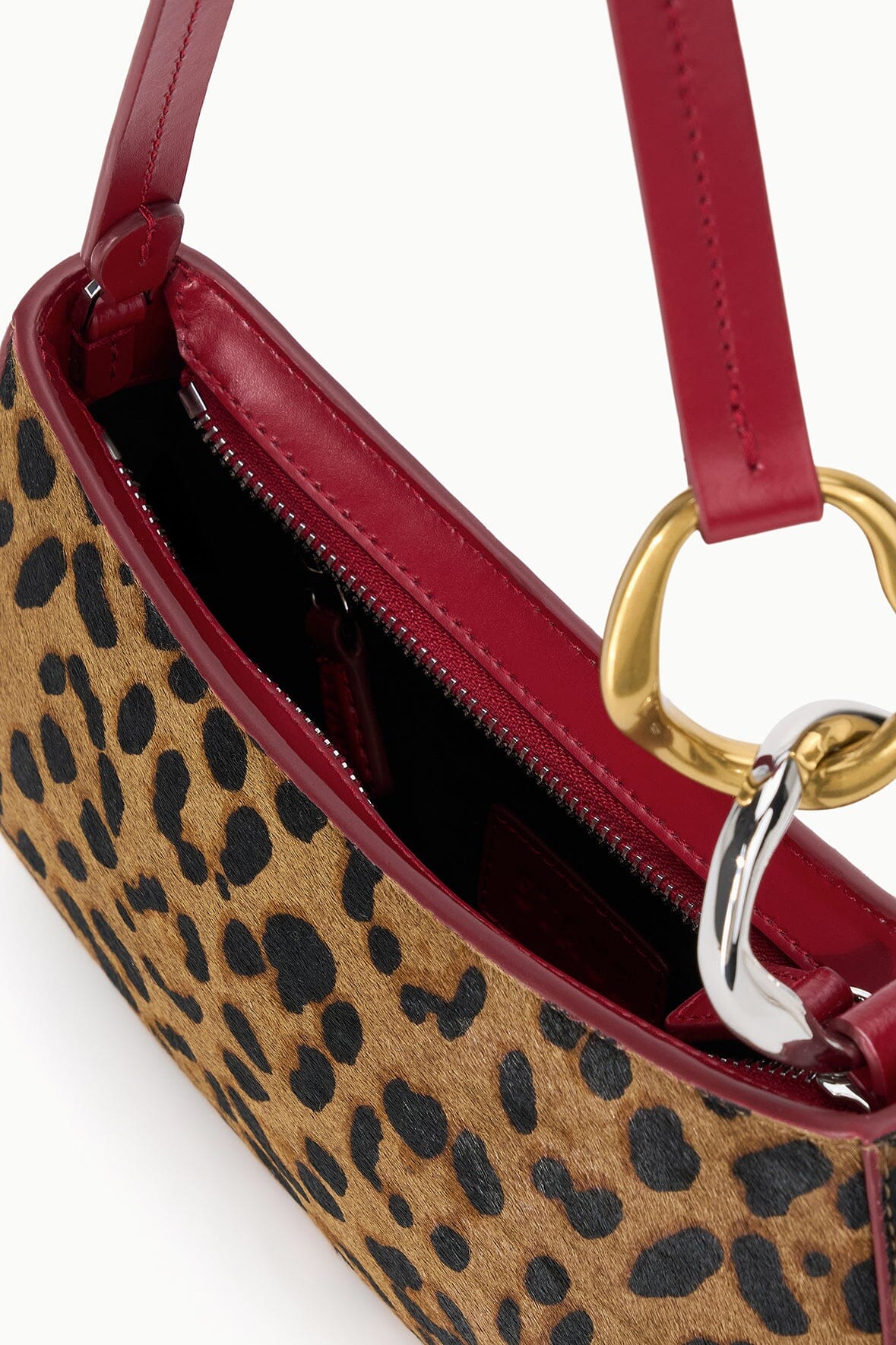 OLLIE bag side view with cheetah print, burgundy leather trim, gold ring hardware