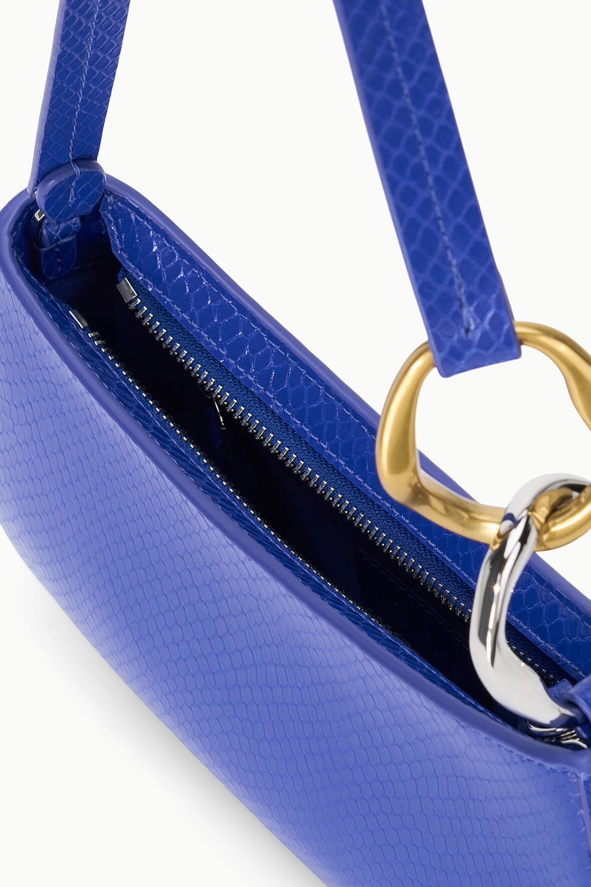 Cobalt blue textured handbag with open top, dark zip pocket, and gold ring strap