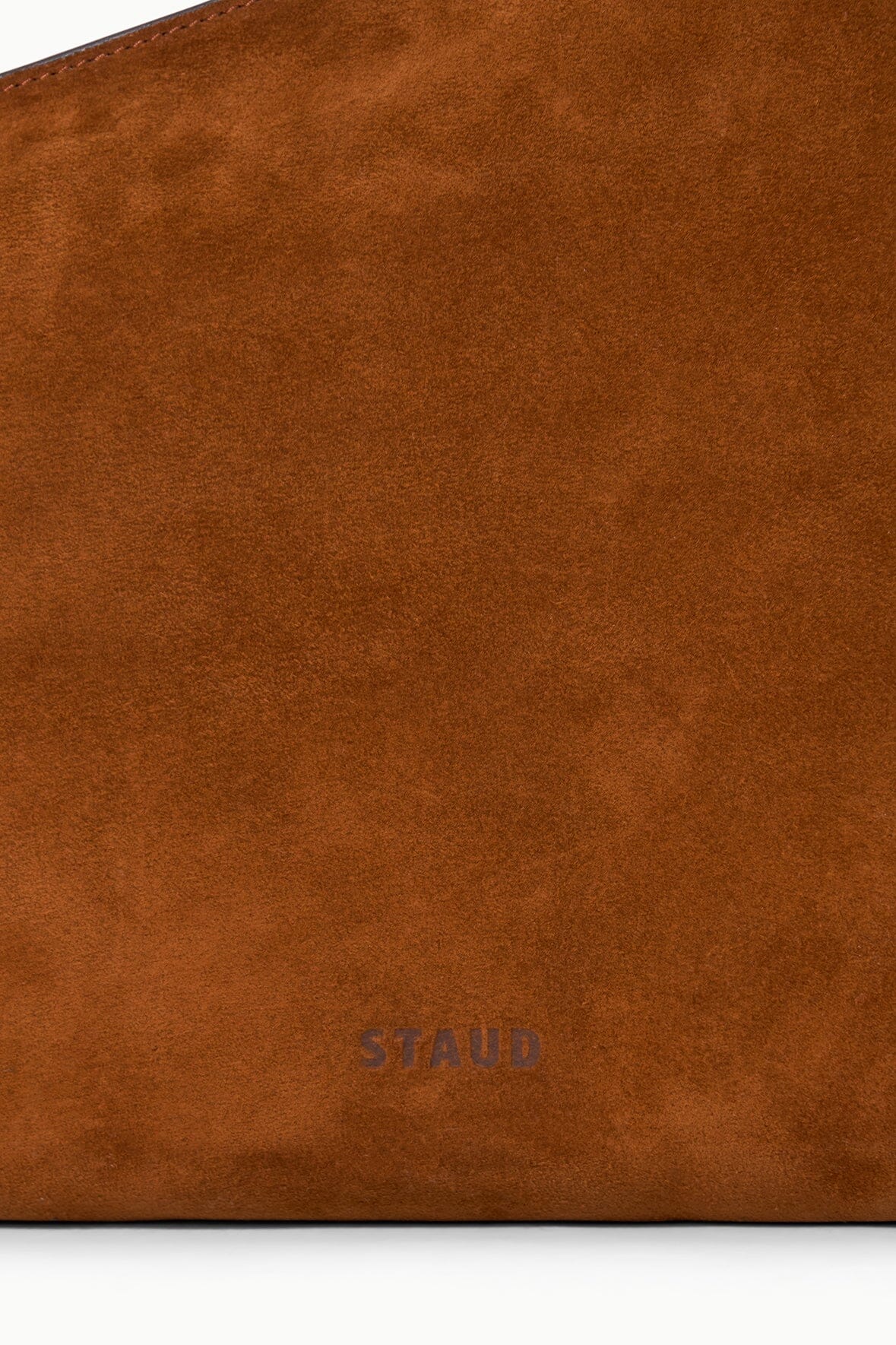 Tabac suede shoulder bag close-up with STAUD logo embossed near the bottom