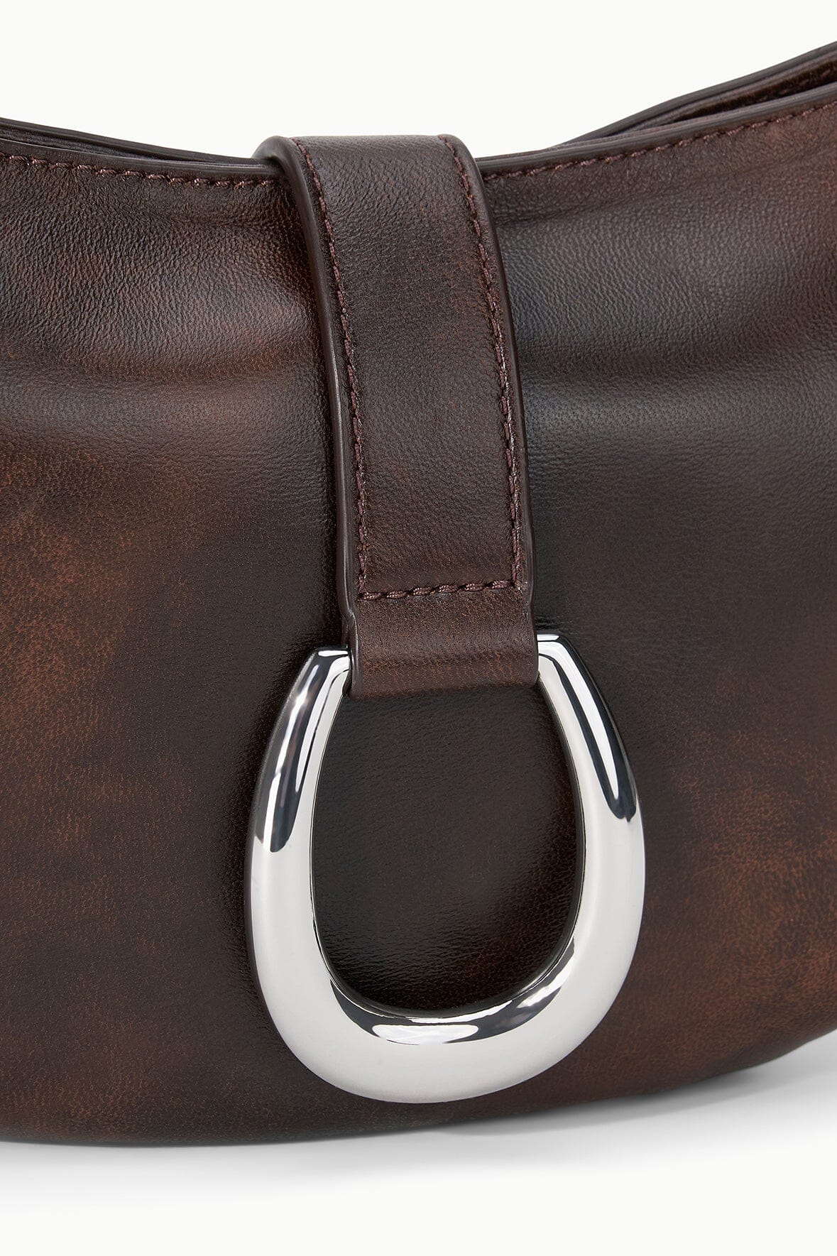 Close-up of Espresso-brown crescent bag with silver O-ring clasp and stitched strap