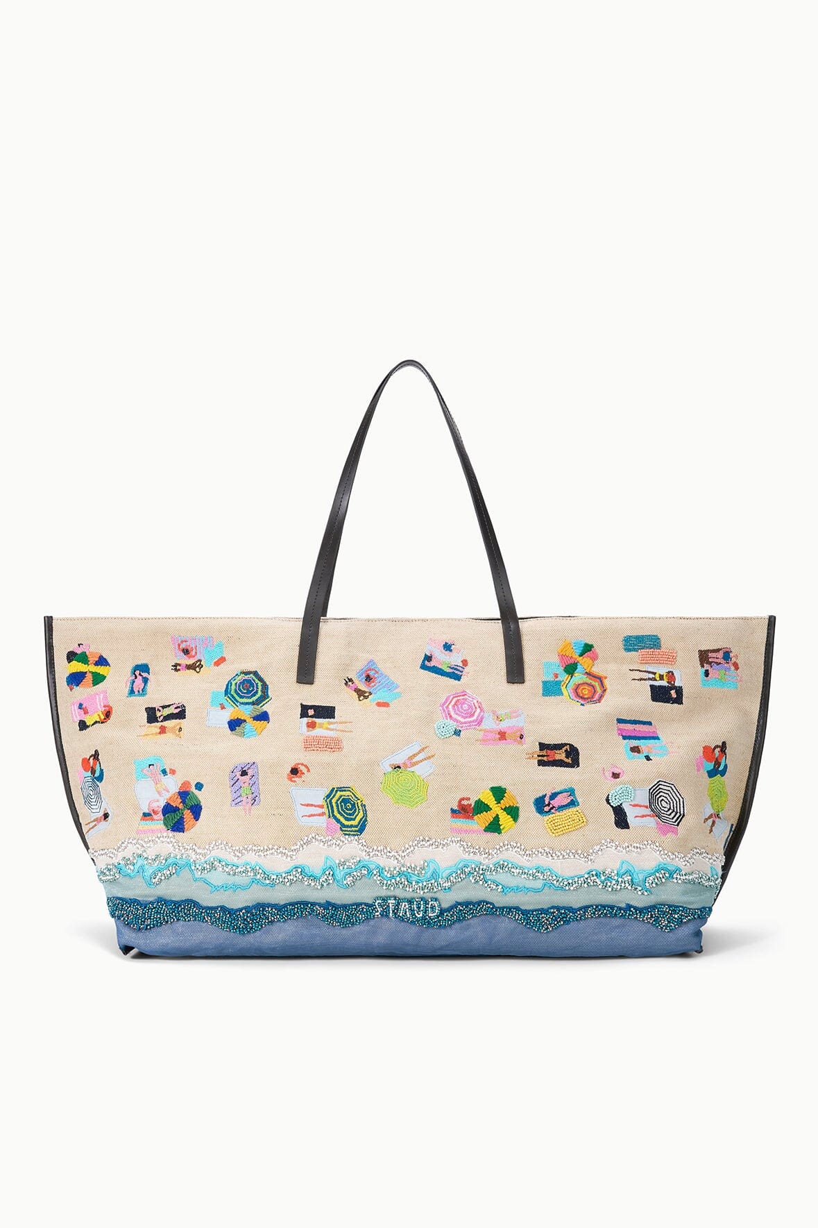 Large printed tote bag with beach-themed artwork and blue bottom, held by black double handles