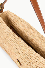 Natural tan raffia tote bag interior view with brown leather strap and clasp
