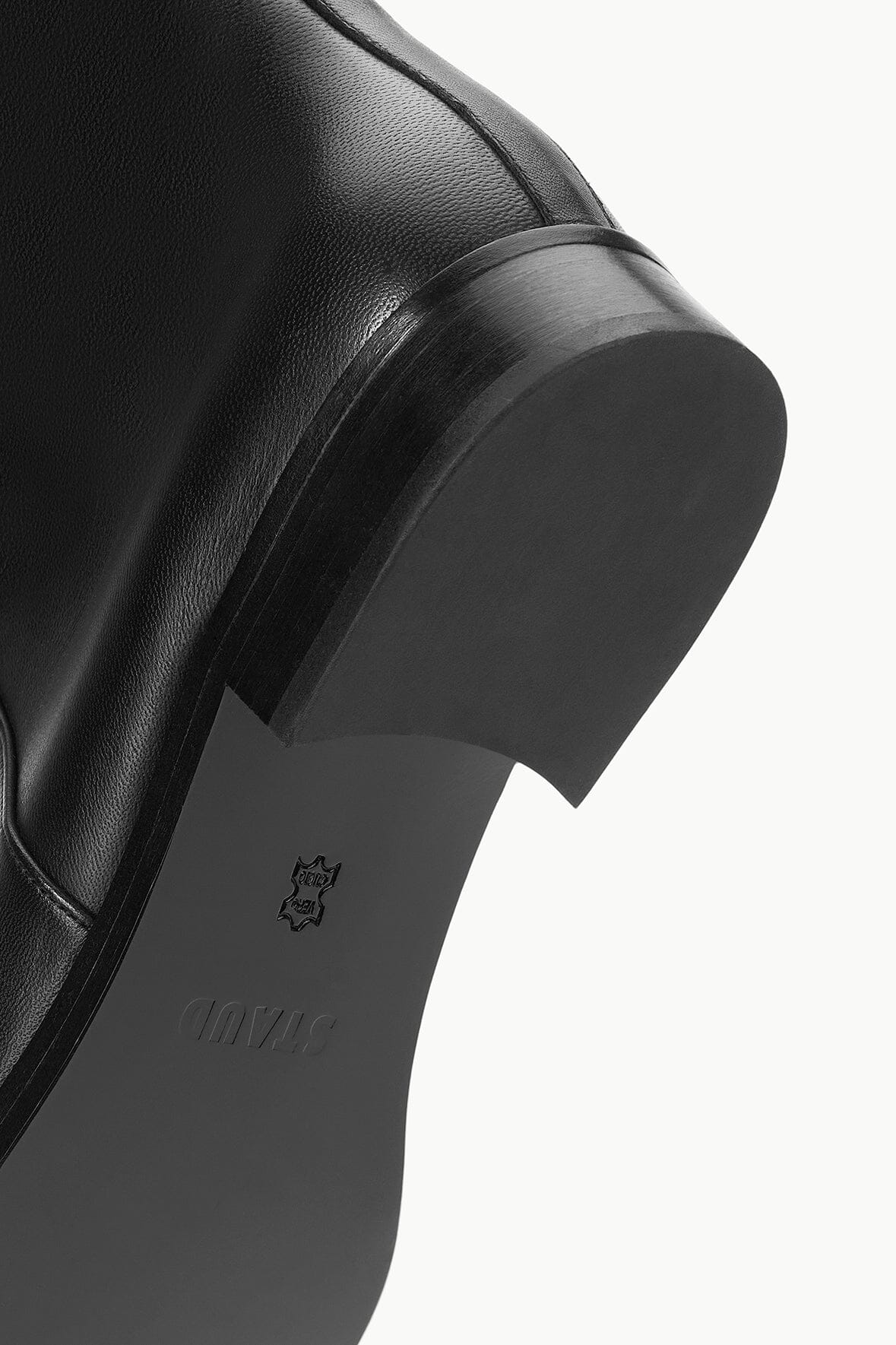 Black riding boot outsole and small logo patch on heel