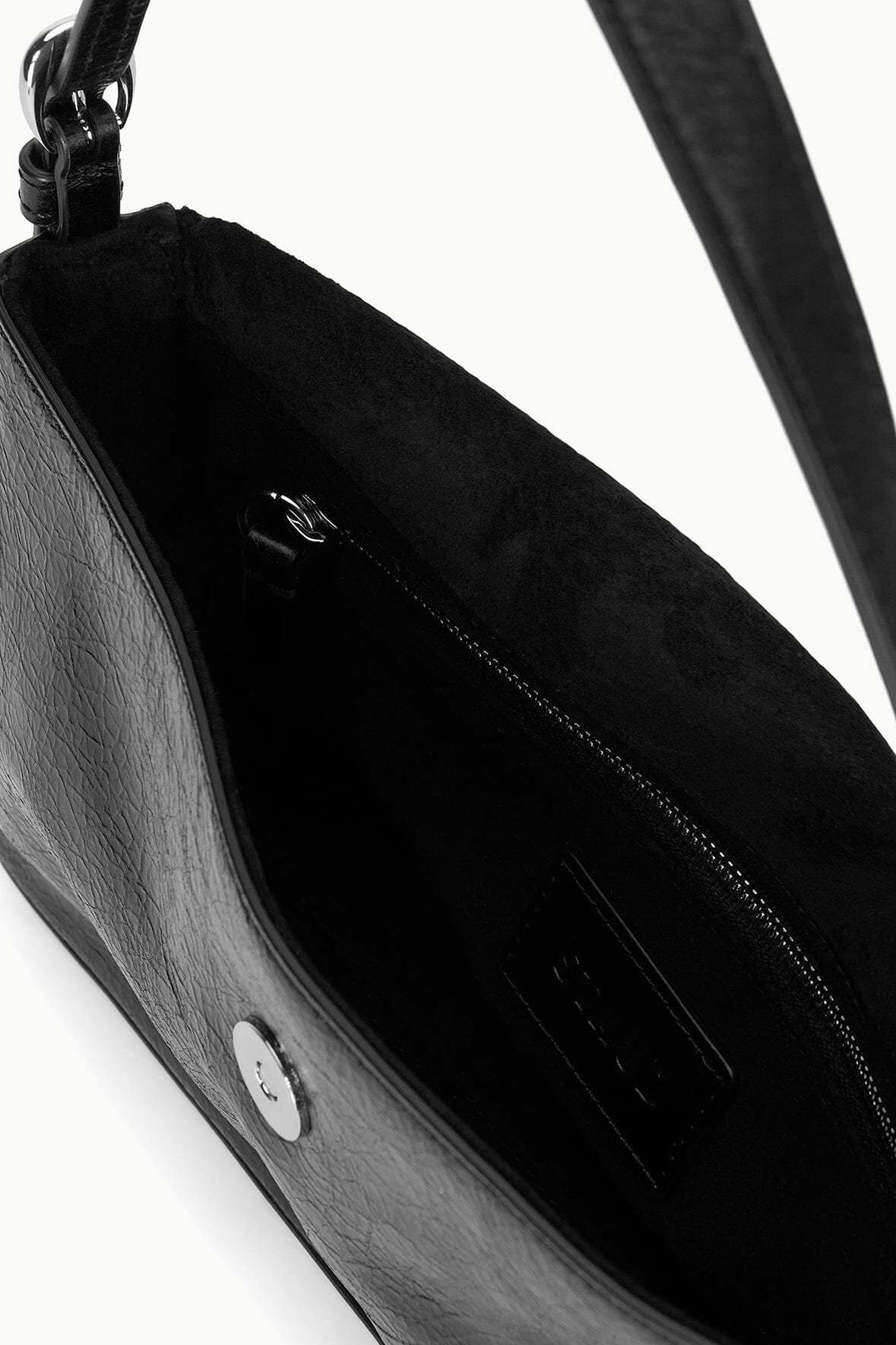 Black leather handbag interior with zipper and top hardware, side view