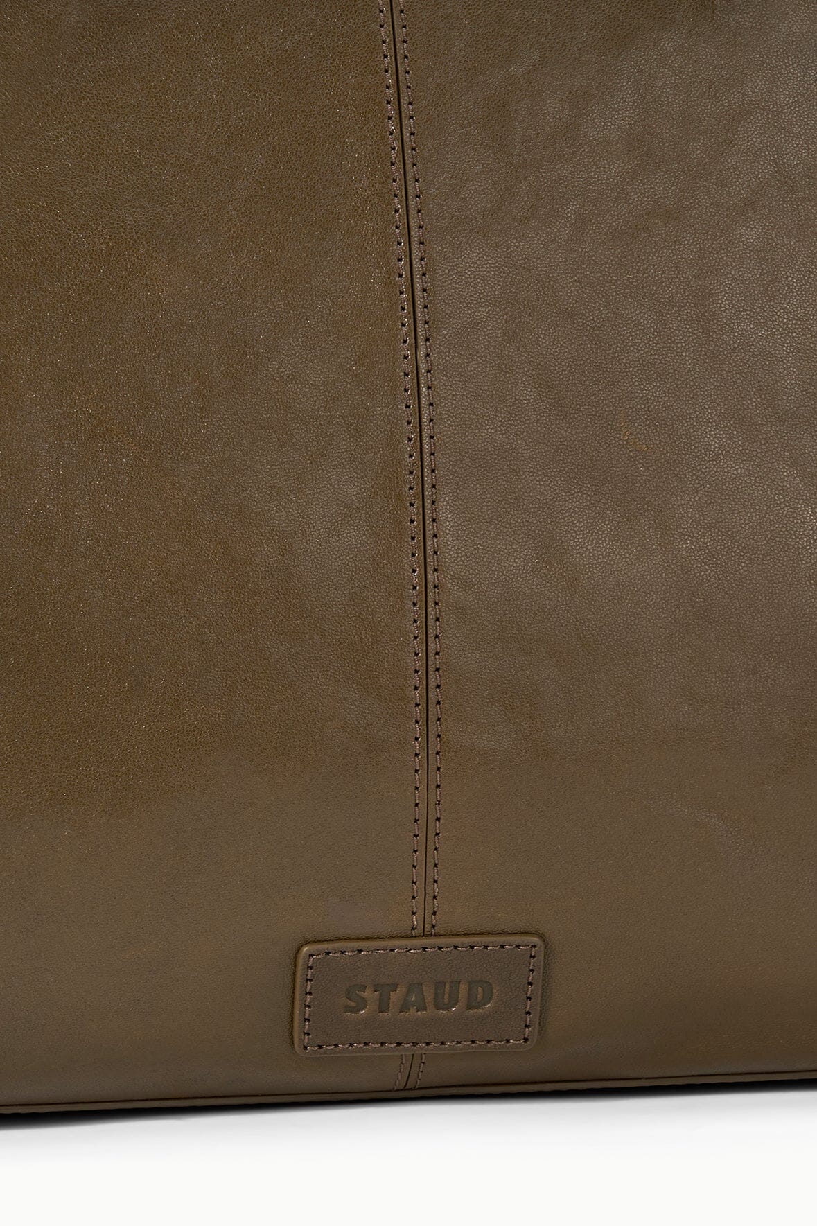 Truffle brown satchel front with stitched edge and STAUD label patch.