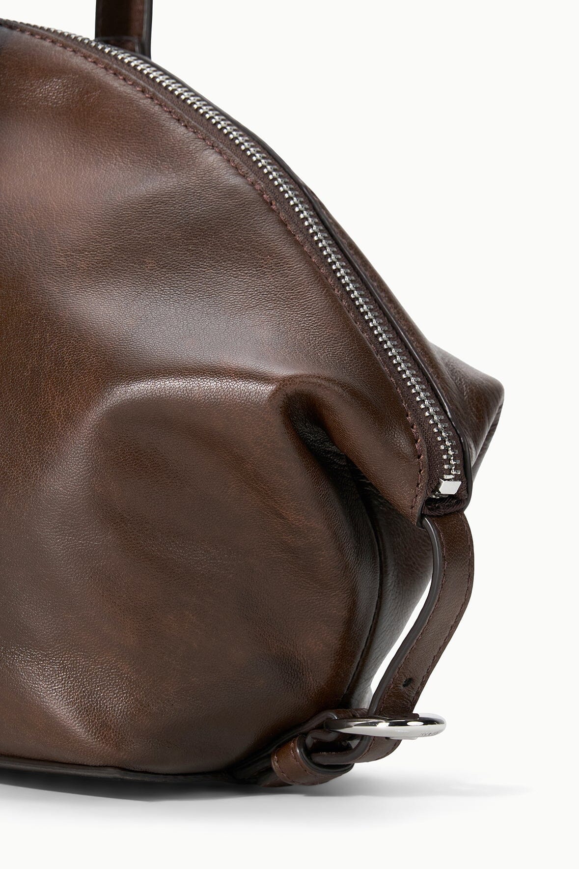 Espresso distressed shoulder bag corner with metal D-ring strap and silver zipper
