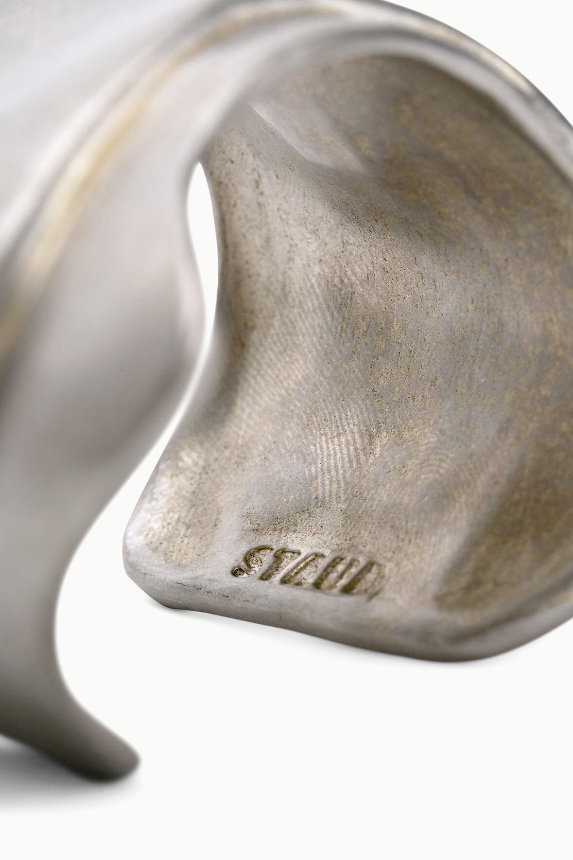 Silver-toned metal cuff bracelet close-up of inner stamp