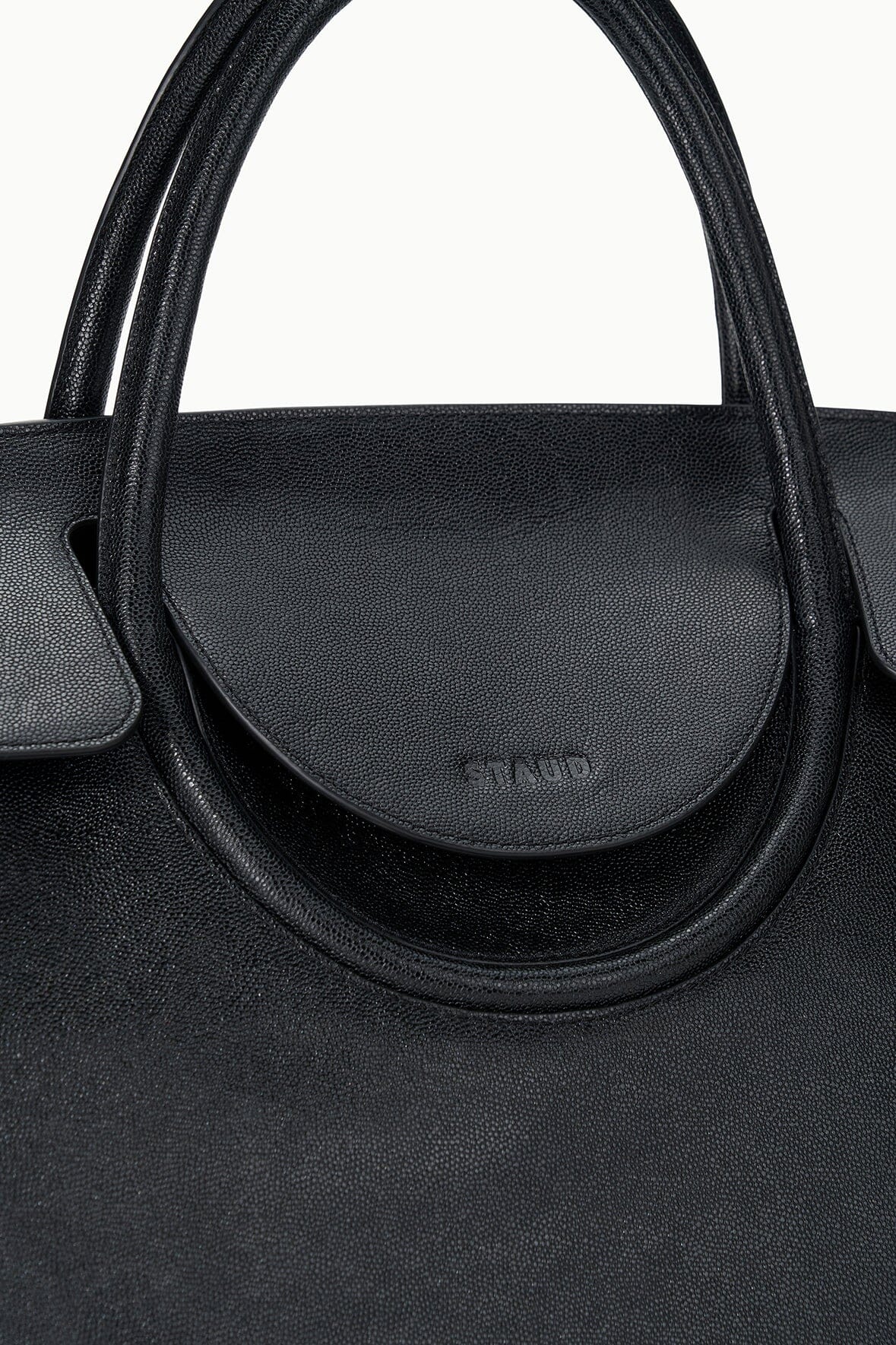 Black Maude carryall close-up of rounded front flap with logo